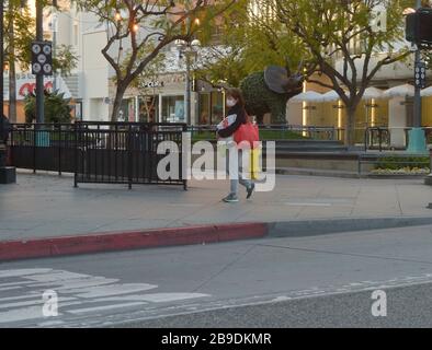 Los Angeles, California, Stati Uniti . 24 Marzo 2020. Una donna passa davanti al deserte centro commerciale Third Street a Santa Monica lunedì 23 marzo 2020. Il sindaco di Los Angeles Eric Garcetti ha chiuso gli sport e le attività ricreative nei parchi della città di Los Angeles e ha chiuso il parcheggio nelle spiagge della città dopo aver visto troppe persone nelle immediate vicinanze che impacchettano spiagge, sentieri e parchi. Garrett ha chiesto ai residenti di rimanere a casa e salvare vite. Le distanze sociali richiedono che le persone rimano ad almeno sei piedi di distanza. Credito: UPI/Alamy Live News Foto Stock