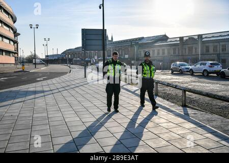 La polizia britannica dei trasporti pattuglia il perimetro della stazione ferroviaria di Bristol Temple Meads, che è vuota di pendolari e viaggiatori nelle ore 8 del giorno dopo che il primo ministro Boris Johnson ha messo il Regno Unito in una situazione di blocco per contribuire a frenare la diffusione del coronavirus. Foto Stock