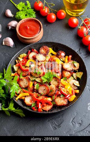Verdure grigliate con salsicce ed erbe in padella, primo piano Foto Stock