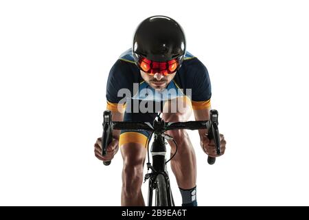 Triathlon atleta maschile ciclo di allenamento isolato su sfondo bianco studio. Il triatleta caucasico si esercita in bicicletta indossando attrezzature sportive. Concetto di stile di vita sano, sport, azione, movimento. Foto Stock