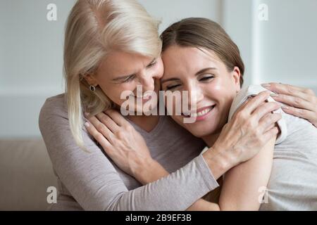 Felice sorride la madre più anziana e la figlia adulta abbracciando e ridendo Foto Stock