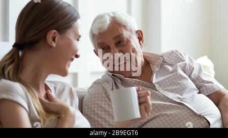 Sorridi padre più anziano e figlia adulta che chiacchierano a casa Foto Stock