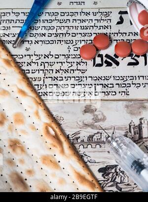 Un Passover Seder all'ombra del virus Corona COVID-19. Matza, pillole, e un'iniezione. Foto Stock