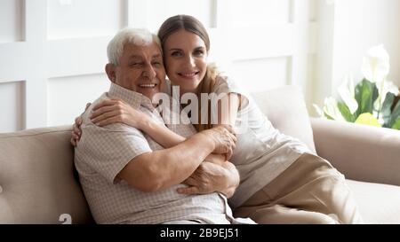 Ritratto buon padre e figlia adulta seduti sul divano Foto Stock