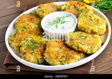 Dieta cotoletta di zucchine, carote, erbe su tavola di legno Foto Stock