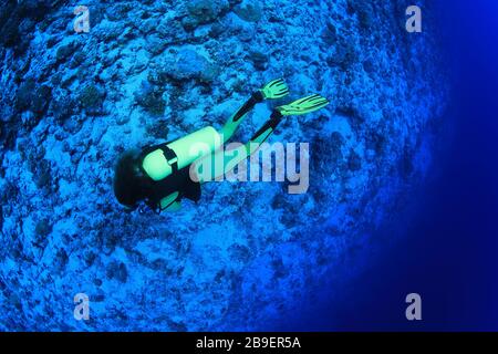 Il subacqueo femminile esplora la bellissima barriera corallina subacquea nelle Maldive Foto Stock