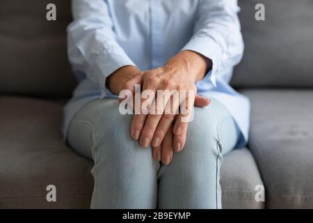 Primo piano della donna anziana sedersi con le mani piegate Foto Stock