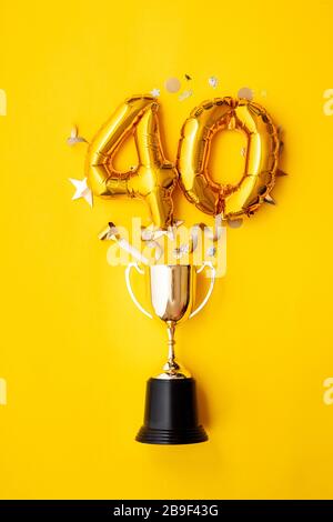 Palloncino numero 40 per la celebrazione dell'anniversario d'oro che esplode da un trofeo vincente Foto Stock