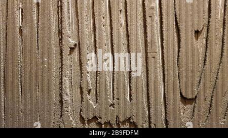 Colla per piastrelle con un modello di ingranaggi. Installazione di piastrelle. La superficie della parete viene ricoperta di pasta adesiva prima della posa di piastrelle o decorativi Foto Stock