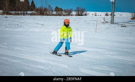 Giovane ragazzo che impara a sciare su una pista in Slovacchia Foto Stock