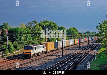 Una locomotiva elettrica di classe 90 numero 90045 che lavora un freightliner ben caricato a South Kenton a Londra. Foto Stock