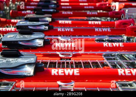 Heinsberg, Germania - Marzo 23. 2020: Primo piano di carrelli a fila isolata della catena di supermercati tedesca Rewe Foto Stock
