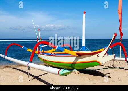 Una barca a vela tradizionale Jukung sulla spiaggia di Sanur, Bali, Indonesia. Foto Stock