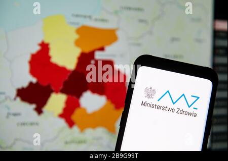 In questa illustrazione della foto viene visualizzato sullo sfondo il logo Ministerstwo Zdrowia 'Ministry of Health in Poland' visualizzato su uno smartphone.UNA mappa che mostra il numero di persone infettate con il coronavirus Covid-19 in Polonia. Foto Stock