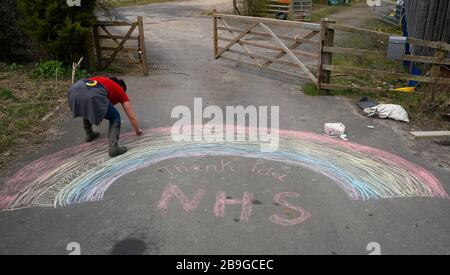 Christina Quigley, 43, da Conkers asilo all'aperto in Rolands Gill, disegno di un arcobaleno sulla sua proprietà con un messaggio di ringraziamento al NHS, il giorno dopo il primo Ministro Boris Johnson mettere il Regno Unito in blocco per contribuire a frenare la diffusione del coronavirus. Foto Stock