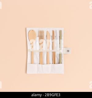 Set di posate di bambù in una custodia su sfondo beige. Concetto di zero sprechi. Foto Stock