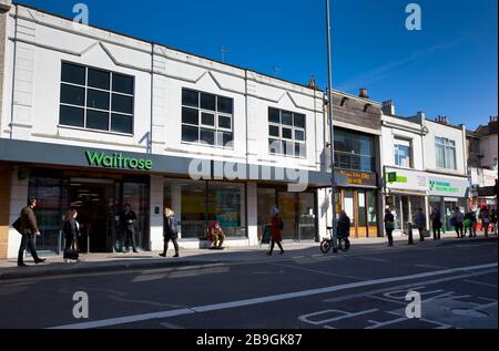 Inghilterra, East Sussex, Brighton, persone in coda con le misure di distanza sociale messe in atto dal supermercato Waitrose per limitare le persone che entrano nel negozio. Foto Stock