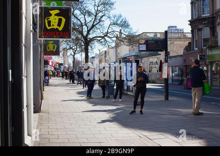 Inghilterra, East Sussex, Brighton, persone in coda con le misure di distanza sociale messe in atto dal supermercato Waitrose per limitare le persone che entrano nel negozio. Foto Stock