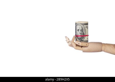 Mano di legno con denaro isolato su sfondo bianco. Rotolo di cento fatture del dollaro. Banconote da 100 USD, valuta in dollari americani con spazio per la copia. F Foto Stock