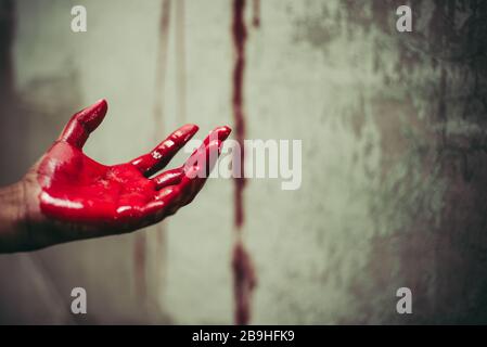 Primo piano di mani sanguinose in abbandono casa sfondo. Horror e fantasma. Concetto criminale e omicida. Giorno di Halloween e tema di sacrificio. Persone Foto Stock