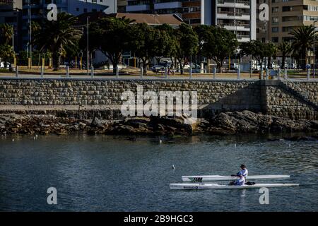 Canoista di mare che ritorna al Mouille Point atterrando nella città costiera sudafricana di Città del Capo dopo aver remato nelle calme acque dell'Atlantico Foto Stock