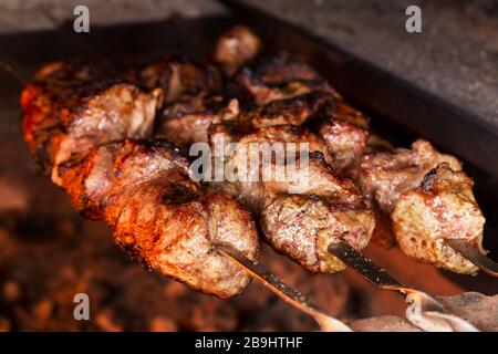 Appetitosa carne alla griglia su spiedini. Cottura shashlik. Grigliare maiale su carbone Foto Stock