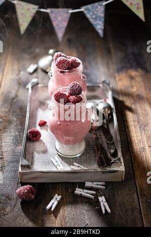 Yogurt cremoso al lampone. Colazione a base di frutta sana. Dessert al latte in vasetti. Cibo delizioso a base di proteine Foto Stock