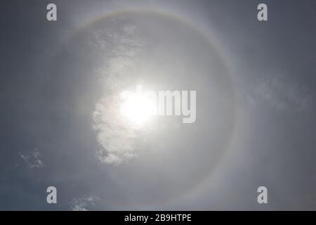 Halo intorno al sole al cielo blu polveroso Foto Stock