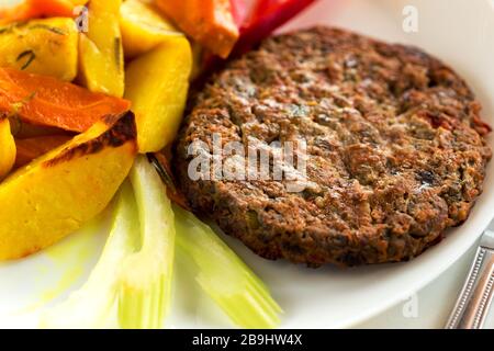 Deliziosa cotoletta di manzo fatta in casa con contorno su piatto bianco Foto Stock