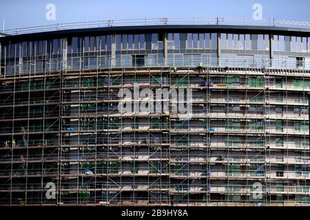 I lavoratori edili in loco presso un blocco di appartamenti a Nottingham il giorno dopo che il primo ministro Boris Johnson ha messo il Regno Unito in una situazione di blocco per contribuire a frenare la diffusione del coronavirus. Foto Stock