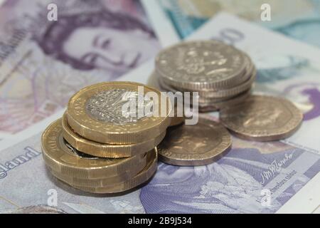 Moneta britannica monete da sterlina £1 e dieci banconote da sterlina, £10, banconote da venti sterline £20 sterline Foto Stock