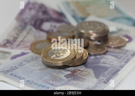 Moneta britannica monete da sterlina £1 e dieci banconote da sterlina, £10, banconote da venti sterline £20 sterline Foto Stock