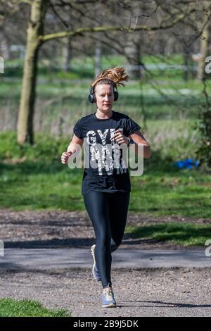 Clapham Common, Londra, Regno Unito. 24 Marzo 2020. Joggers mescolare con gli escursionisti - la gente esce sul Clapham comune per ottenere i loro giorni di esercizio in - la maggior parte pratica sociale a distanza, ma è quasi occupato come un normale giorno di primavera. Il primo giorno dell'epidemia di "blocco" a Clapham - Anti Coronavirus (Covid 19) a Londra. Credit: Guy Bell/Alamy Live News Foto Stock