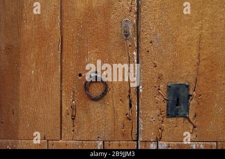 Vecchio portone in legno con chiave e serratura in metallo rotta per metà Foto Stock