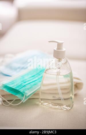 Concetto di prevenzione del coronavirus - maschere da viaggio chirurgiche gel disinfettante per le mani e asciugamano Foto Stock