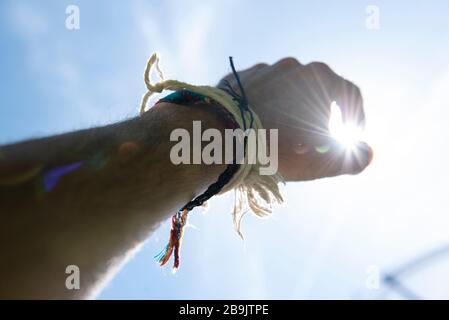 Mano con braccialetti hippy al sole. Fotografia di Danny Fitzpatrick www.dfphotography.co.uk danny@dfphotography.co.uk +44 (0) 7779 606901 Foto Stock