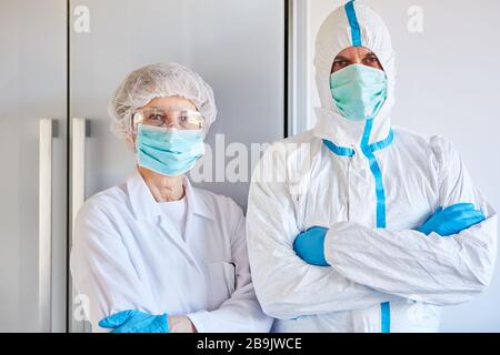 Dipendenti di controllo della malattia in indumenti protettivi durante l'epidemia di coronavirus (Coivd-19) in una clinica Foto Stock