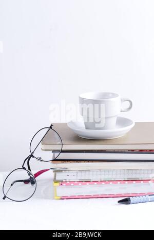 Composizione mattutina da due tazze di ceramica con chicchi di caffè appena tostati e caffè aromatico macinato fresco su sfondo chiaro e palma sempreverde Foto Stock