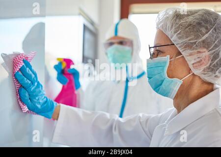 Disinfezione e pulizia nell'unità di terapia intensiva di una clinica con pazienti infettivi Covid-19 Foto Stock