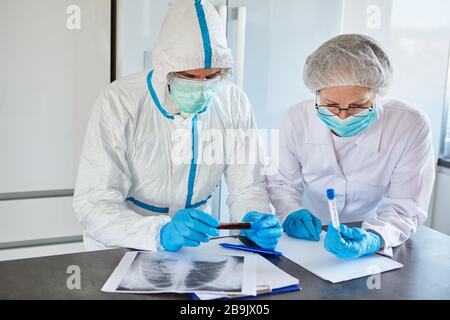 I professionisti medici lavorano in indumenti protettivi presso l'epidemia di Covid-19 in una clinica radiologica Foto Stock