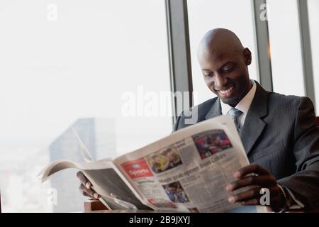 Uomo quotidiano di lettura accanto alla finestra Foto Stock