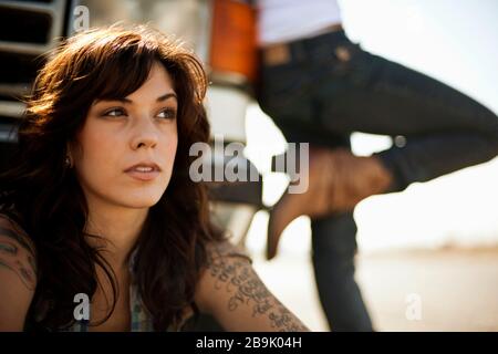 Due amici femminili si appoggiano contro la loro macchina rotta. Foto Stock