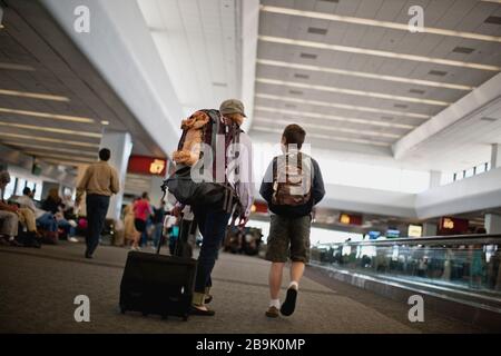 Una madre e un figlio che arrivano all'aeroporto. Foto Stock