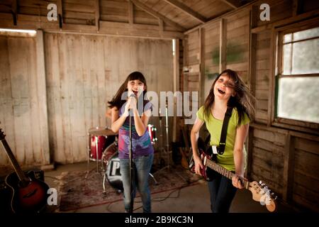 Due ragazze adolescenti che si divertono nella band pratica. Foto Stock