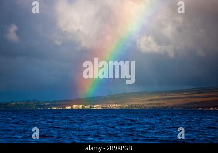 Arcobaleno che si inarcano su edifici su una costa. Foto Stock