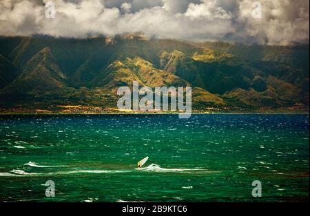 Windsurfer divertirsi in un giorno ventoso sotto le nuvole drammatiche. Foto Stock