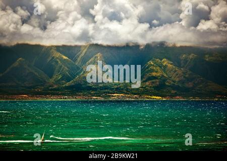 Windsurfer divertirsi in un giorno ventoso sotto le nuvole drammatiche. Foto Stock