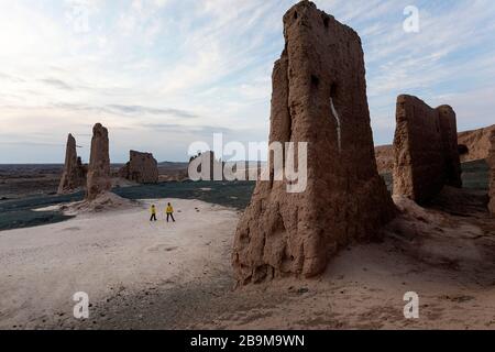 Madre e figlio a rovine mozzafiato di Jampik Kala fortezza situata Kyzylkum deserto nella regione di Karakalpakstan in Uzbekistan Foto Stock