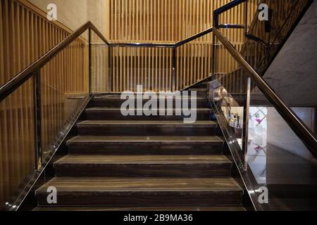 Scala lussuosa con gradini in marmo e ringhiere decorative e ornamentali in ferro e vetro. Eleganti scale storiche in interni di lusso all'interno di un h. Foto Stock