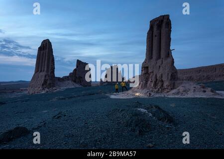 Madre e figlio con un faro leggero presso le rovine mozzafiato della fortezza di Jampik Kala situato nel deserto di Kyzylkum nella regione di Karakalpakstan in Uzbekistan Foto Stock